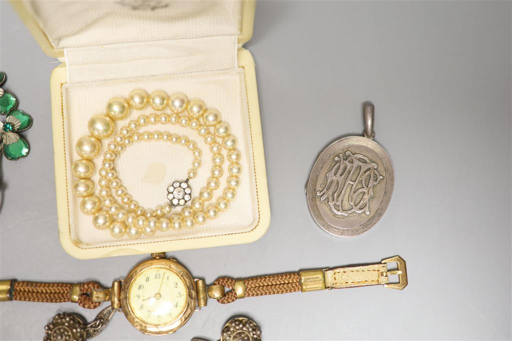 A ladys 585 yellow metal manual wind wrist watch, gross 23.2 grams, a white metal locket and other minor jewellery.